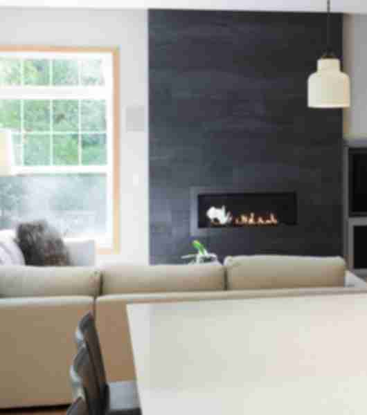 Living room with a fireplace with black large-format tile.