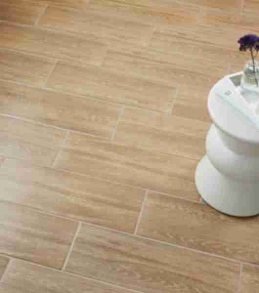 Ceramic wood-look tile floor with small white table.