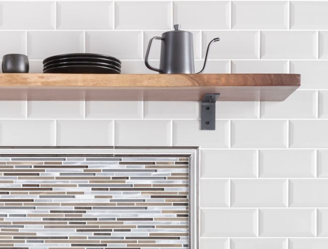 Coffee bar in kitchen with white bevel-edge subway tile and metallic stria accent tile as backsplash.