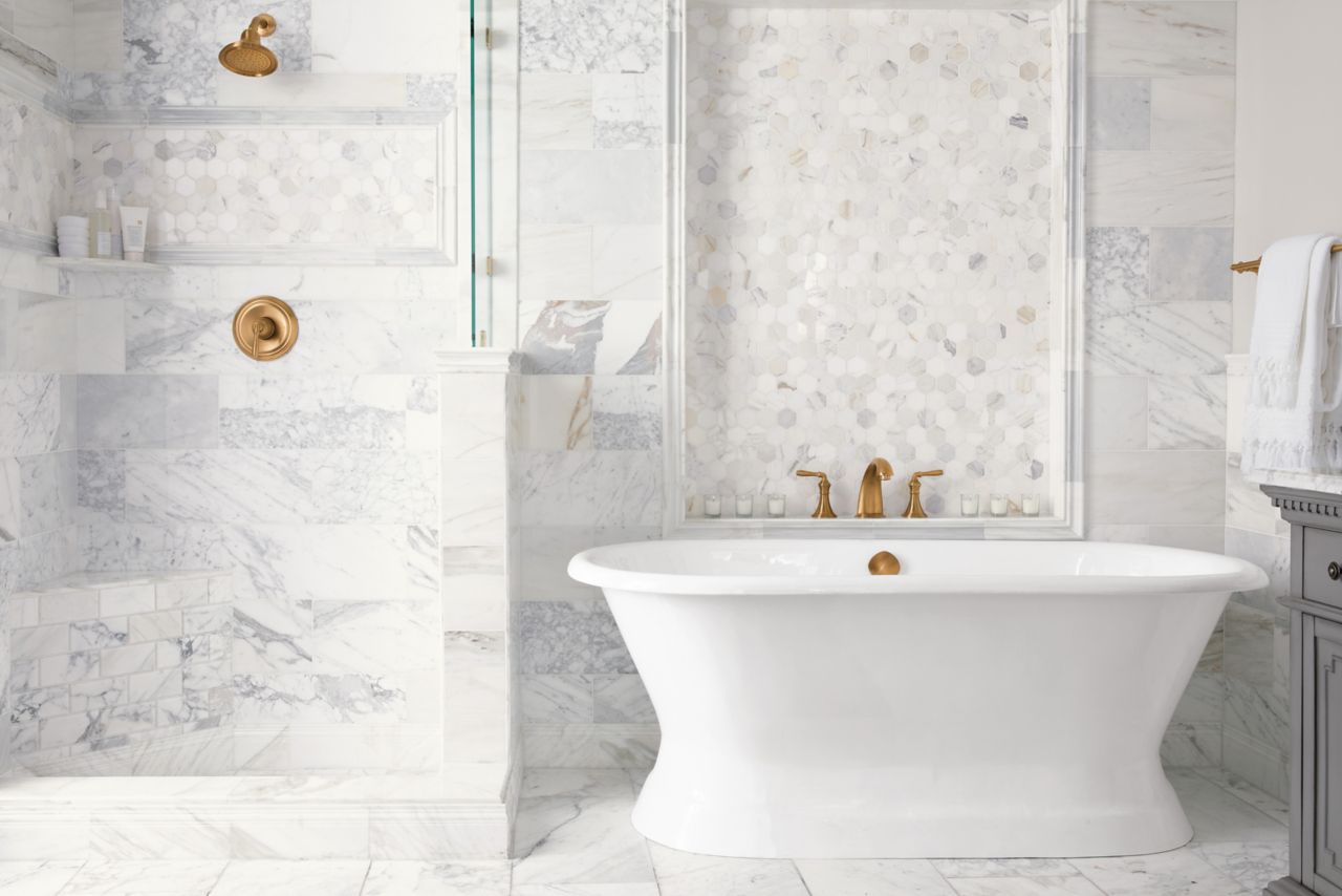 Italian marble has a polished finish and displays a cloudy white base with gold veining, providing these bathroom walls and floors with elegance.