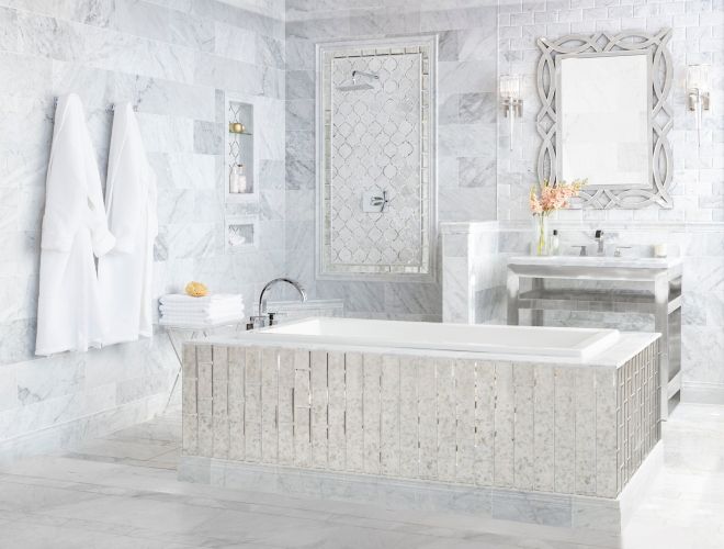 Elegant bathroom with white marble tile and antique mirror accents.