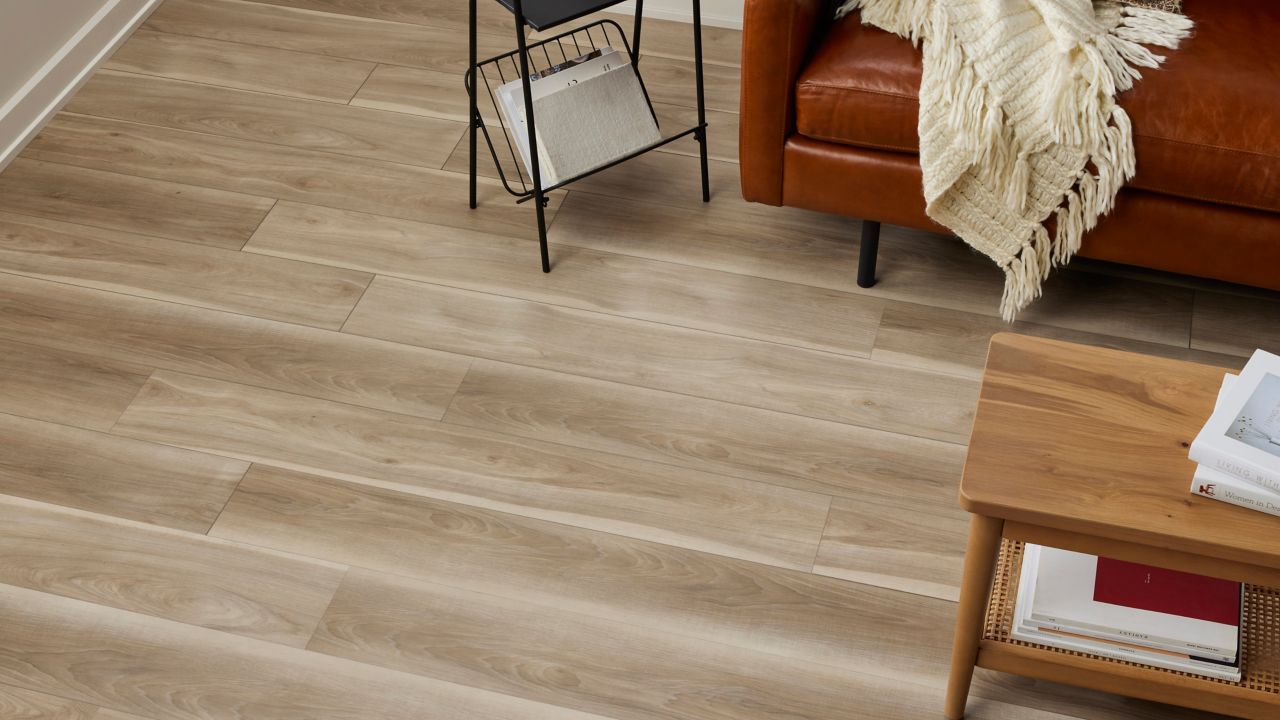 The floor of a living room is covered with luxury vinyl wood-look planks that have a realistic appearance of blonde-toned wood.