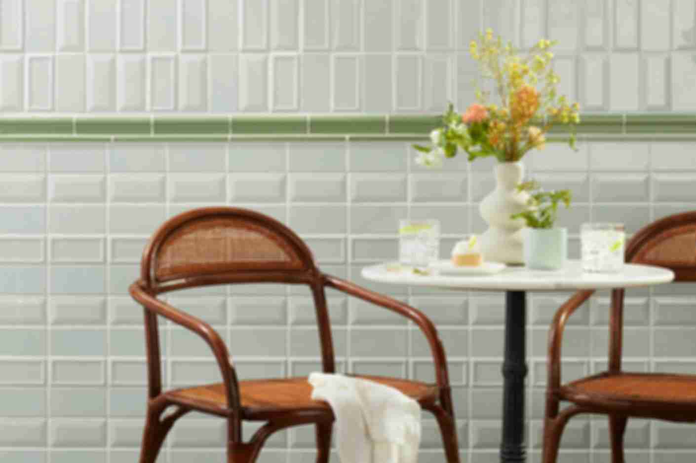 Green kitchen wall tile in vertical and horizontal stack with table and chairs.