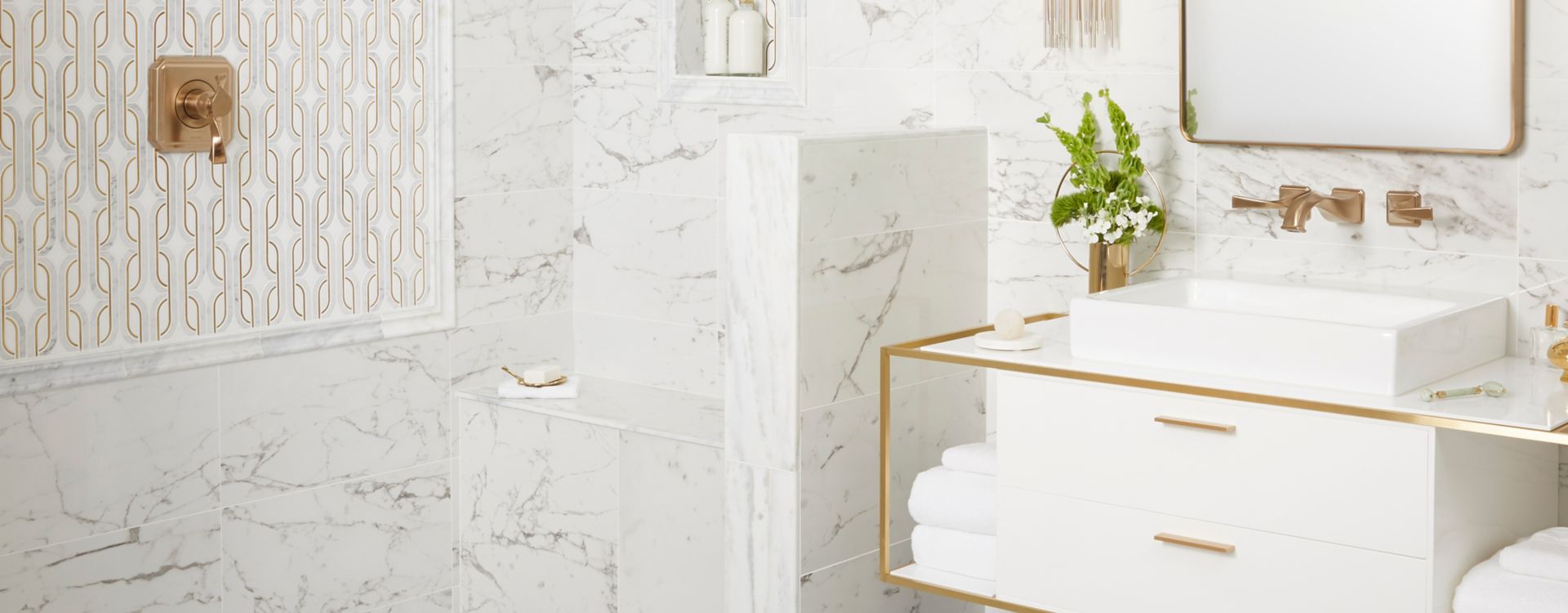 Glamorous bathroom with white marble and gold accents.