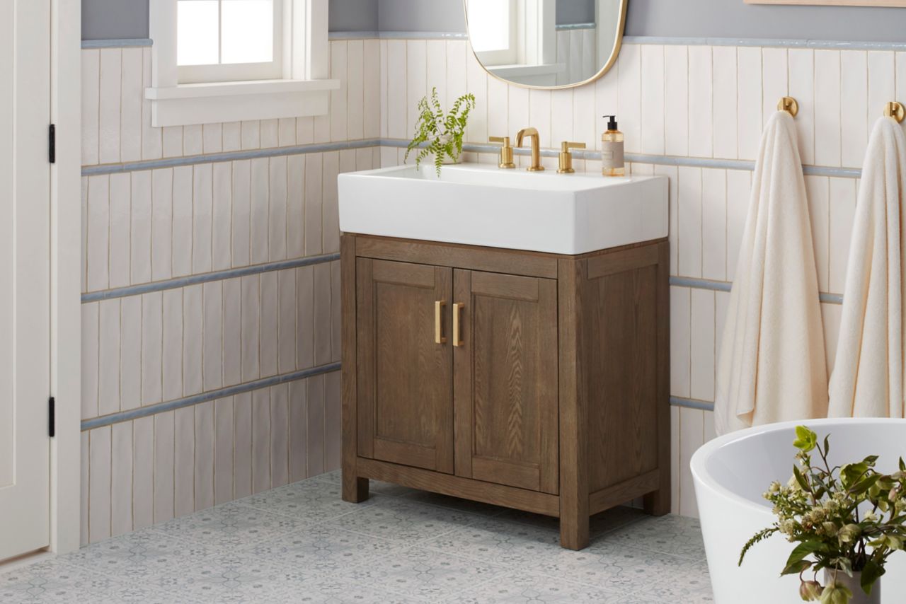 Bathroom with lace-patterned floor and white subway tile wall with three bands of blue pencil trim.