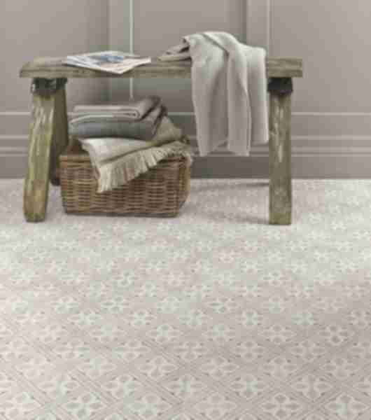 Photo focuses on floor tile in a fabric pattern in a dove grey with a lattice like print.