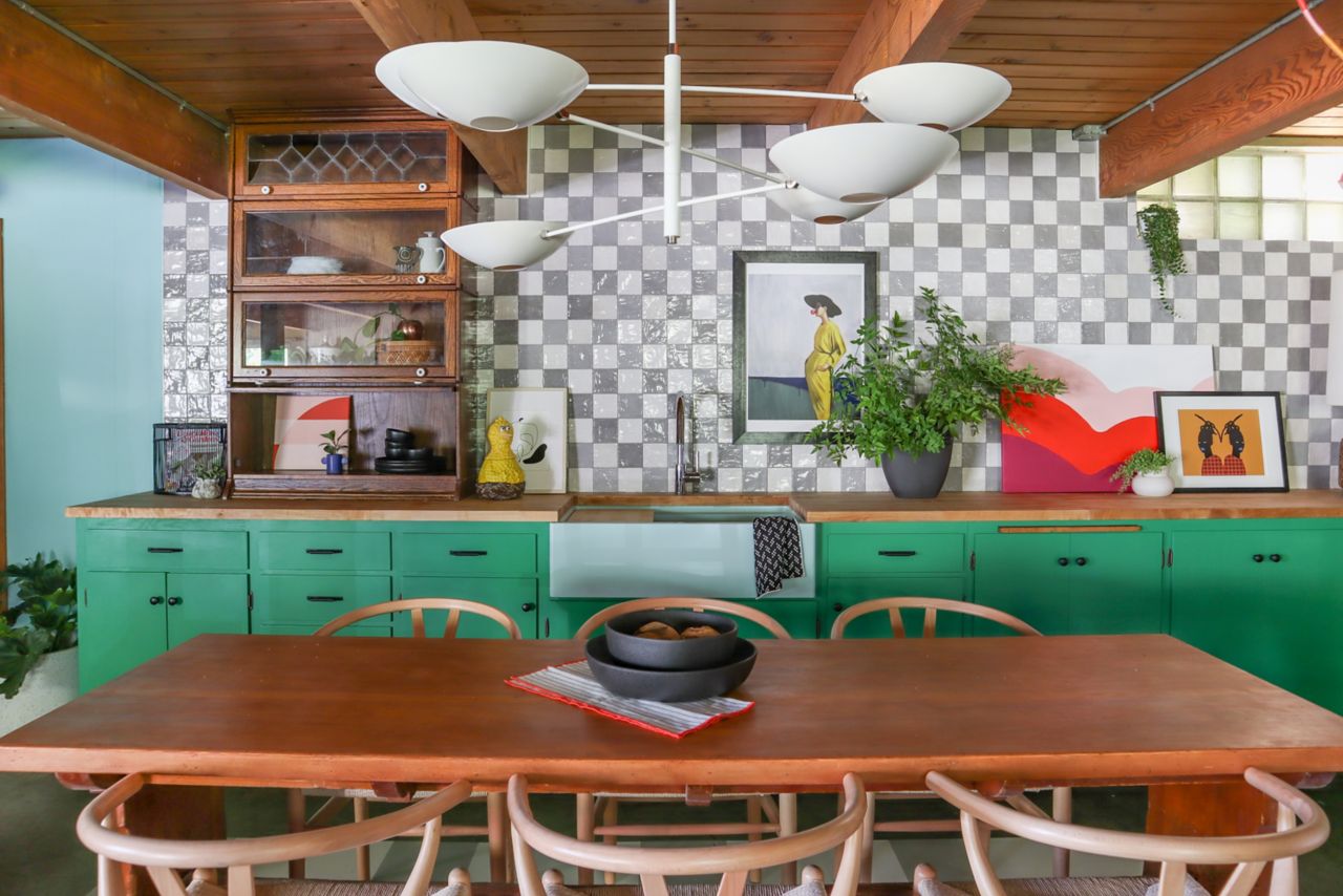 White and grey checkerboard ceramic tile wall in a kitchen with green counters and table and chairs.