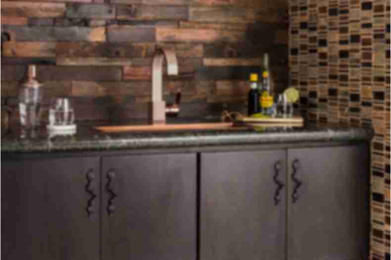 Dark brown reclaimed wood wall tile with dark brown mosaic above bar area.
