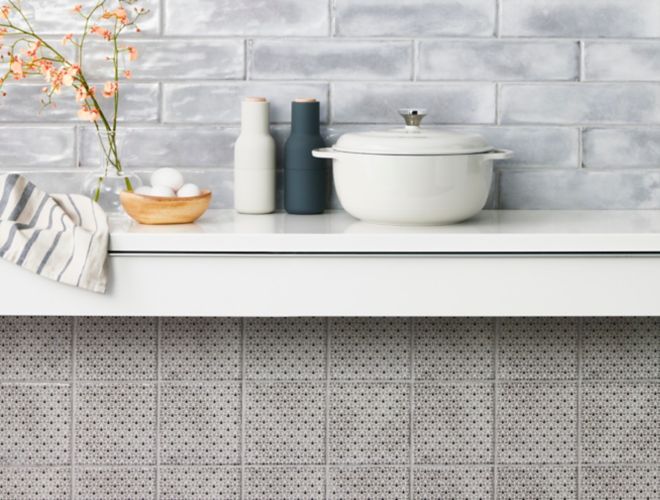 Kitchen backsplash with grey subway tile and square patterned wall tile.