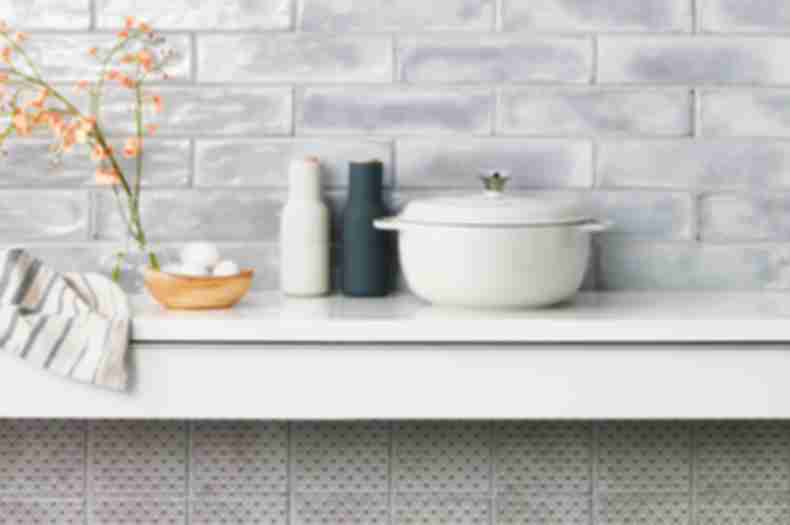 Kitchen backsplash with grey subway tile and square patterned wall tile.