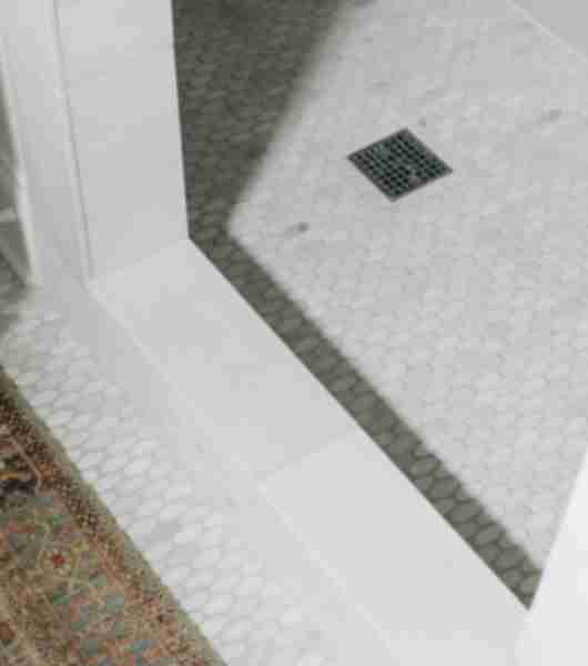 Shower threshold with white tile.