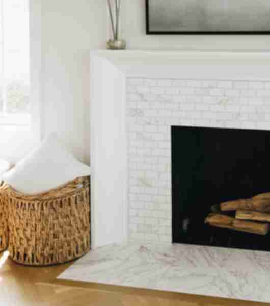 White marble mosaic fireplace surround, with wicker basket.