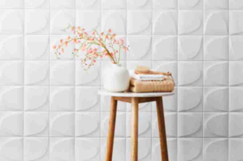 White ceramic 3-D wall tile in spa-like bathroom.