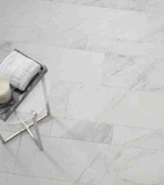 Aerial shot of a white marble subway tile floor with a small table.
