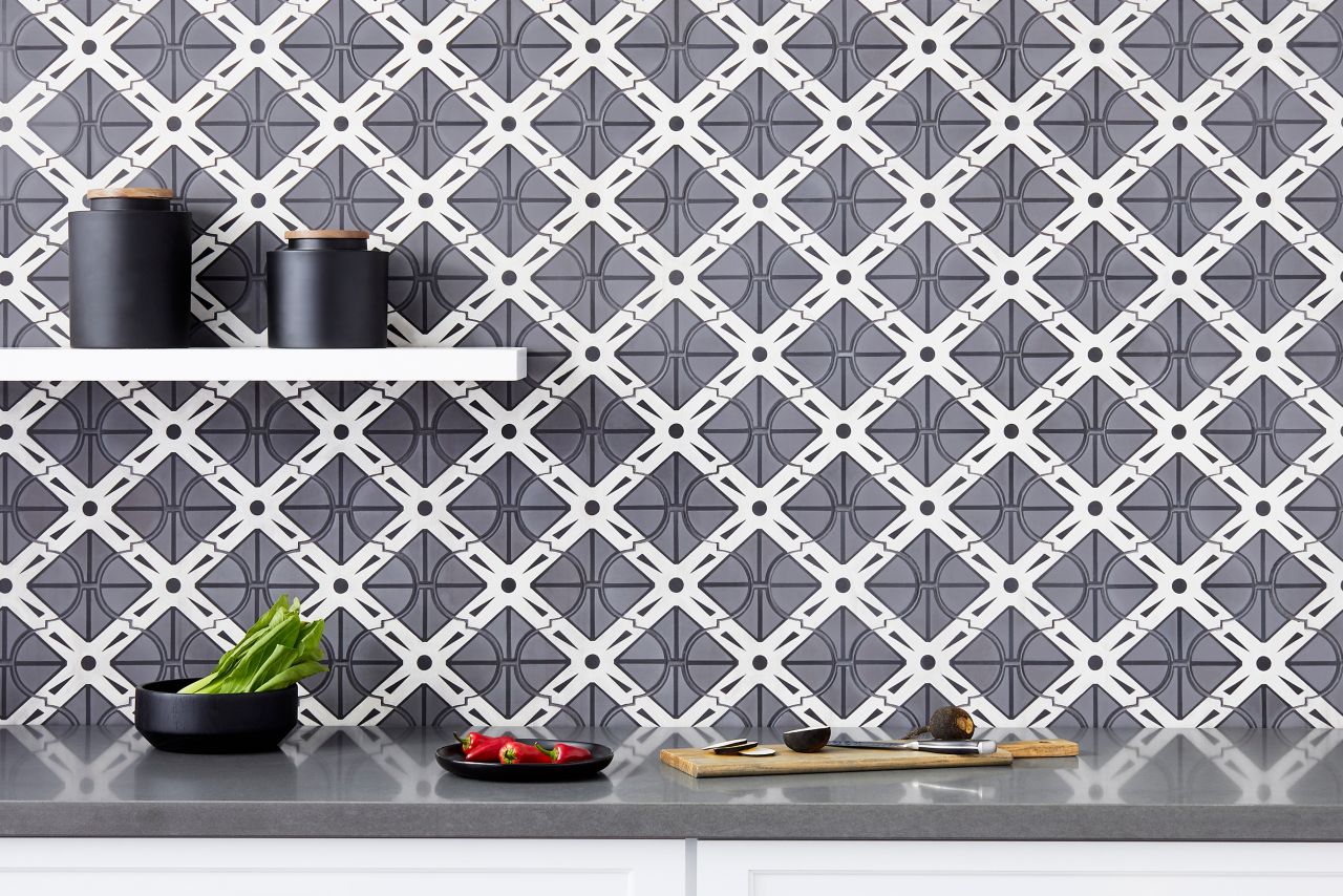 Kitchen backsplash using tile with a bold geometric design in black, grey and white is tempered by the soft, feminine arabesque shape.