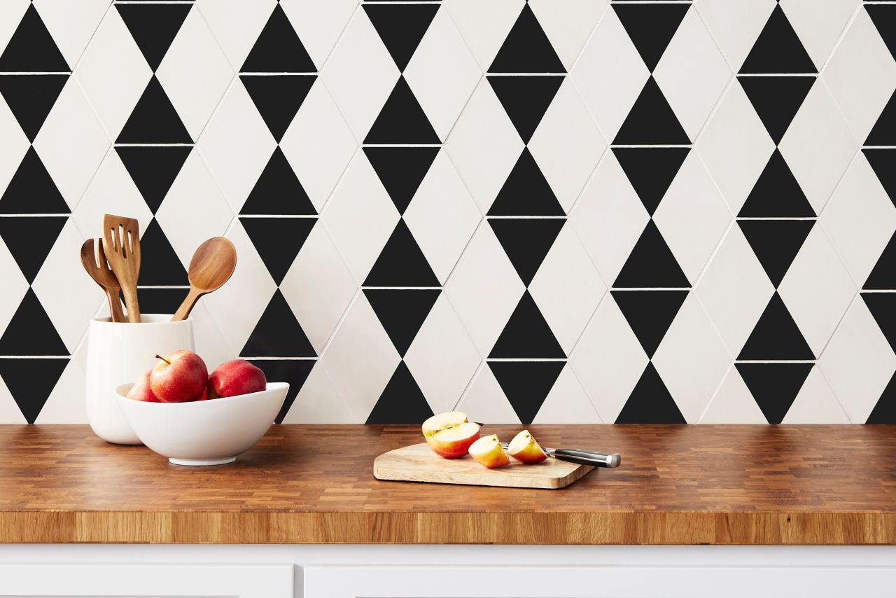 Kitchen with a chic black-and-white accent wall. With the diamonds and triangles on this hexagon tile it creates a woven geometric design. 