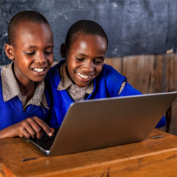 两个小学生在偏远地区使用笔记本电脑上网
