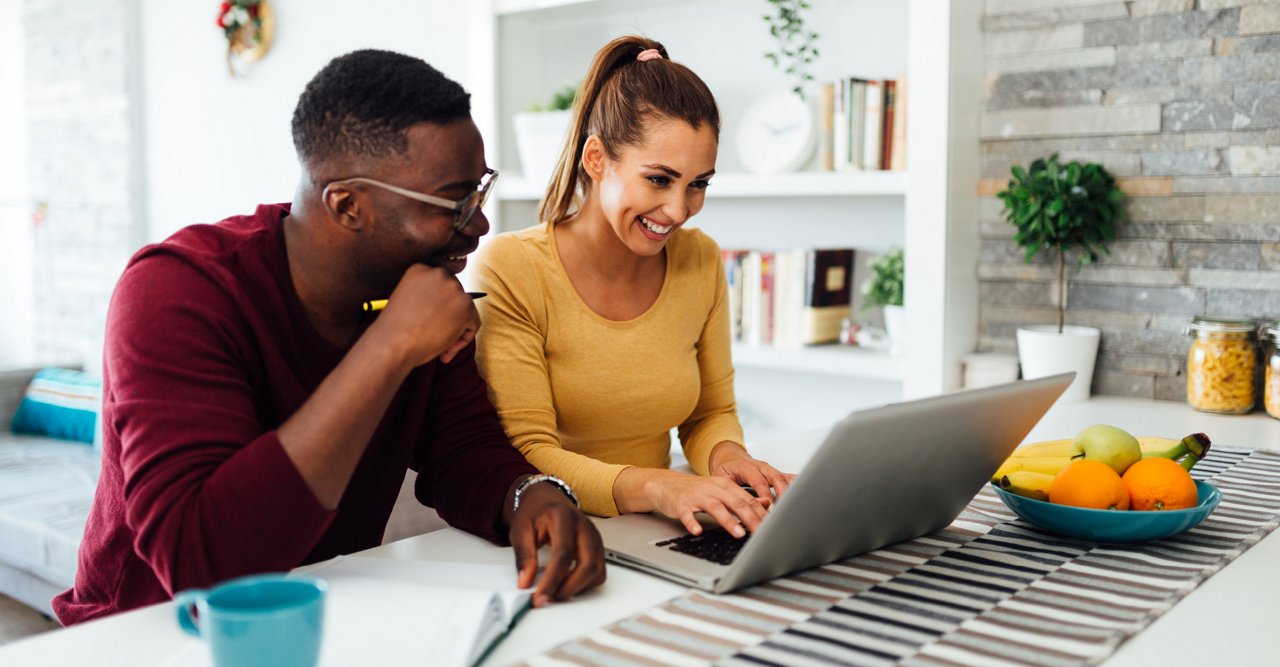 Couple working together on laptop at home