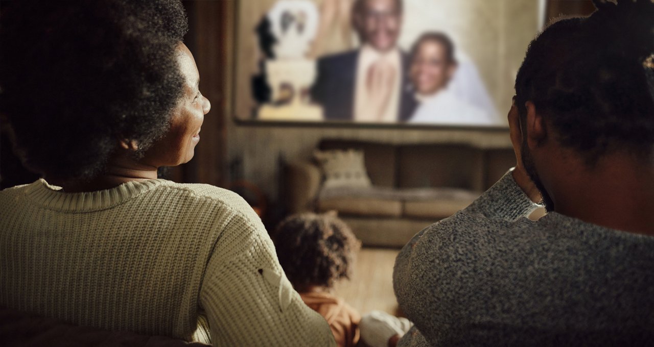 Parents regardant leur vidéo de mariage avec leur enfant