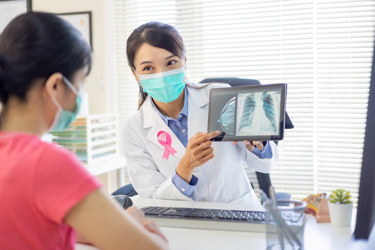 doctor holding photo of chest xray and showing to woman