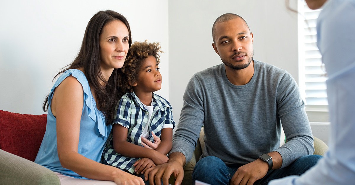 A cheerful couple is hosting a fun gathering at their home, surrounded by a group of delighted friends and family.