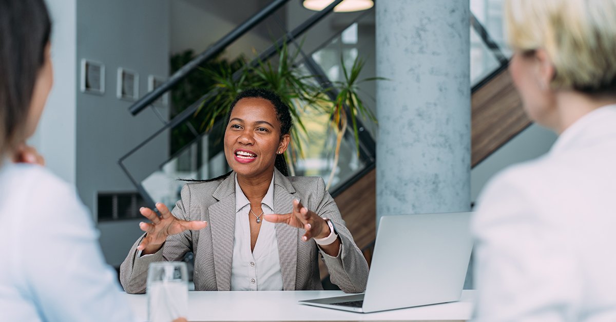 financial advisor sitting a desk with 2 clients.