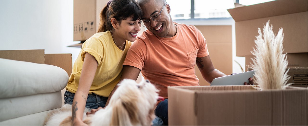 Un couple joyeux, dégageant du bonheur, forme une image de famille radieuse dans le confort de leur maison.