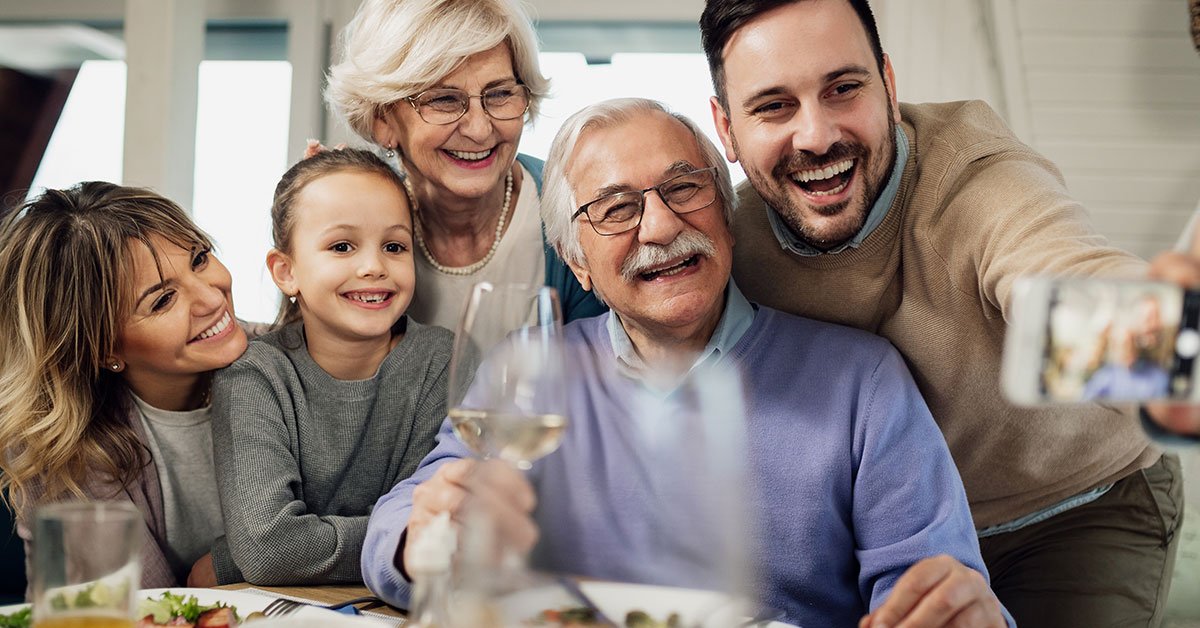 A young, happy woman enjoys a lively gathering with family, friends, and her supportive father.