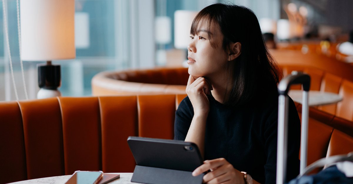 Woman gazes out in airport lobby