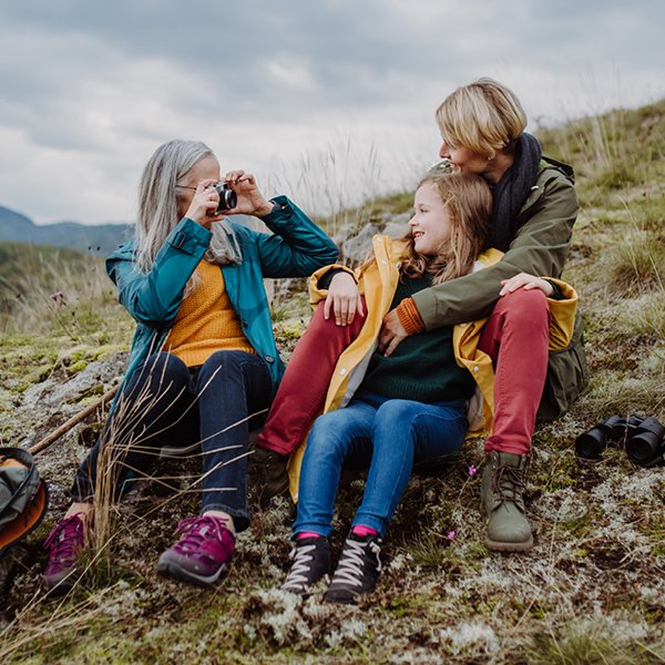 A joyful young mother is enjoying an outdoor excursion with her children, creating happy family memories.