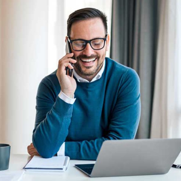 Un homme d'affaires professionnel adulte est en pleine communication à l'aide de son ordinateur portable dans son bureau.