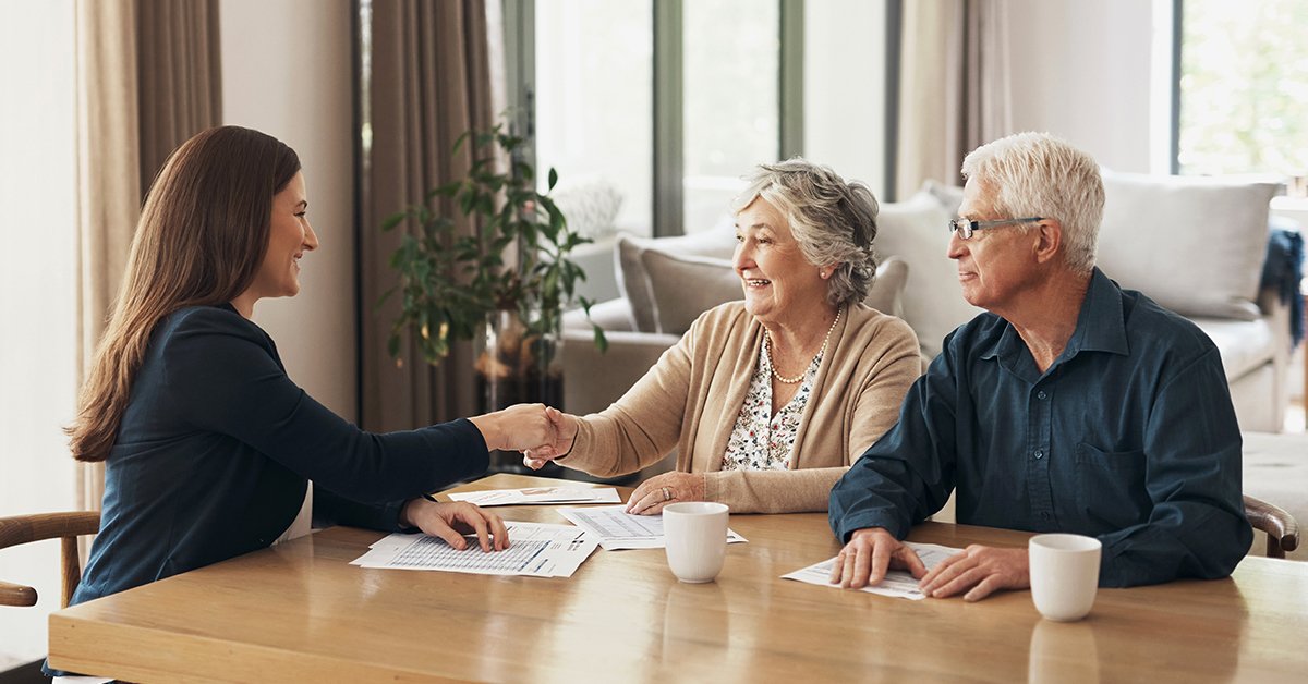 Un couple de seniors satisfaits, tous deux professionnels, exprime leur bonheur dans leur confortable maison.