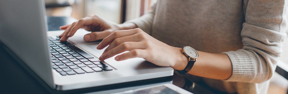 Une femme d'affaires dans un environnement de bureau manipule habilement la technologie, ses mains tapant adroitement sur le clavier d'un ordinateur portable.