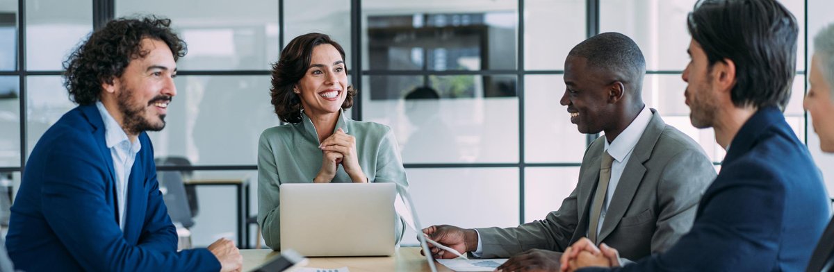 Une équipe professionnelle, composée d'hommes et de femmes d'affaires, collabore dans un bureau, utilisant des ordinateurs portables et des postes de travail.