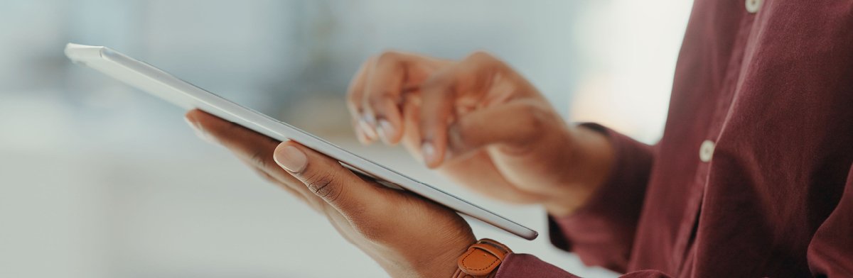 A hand holding a tablet computer, emphasizing the interaction with digital technology.