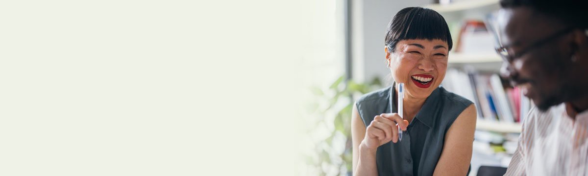 Une jeune femme et un jeune homme d'affaires échangent dans un cadre professionnel, promouvant la collaboration en entreprise.