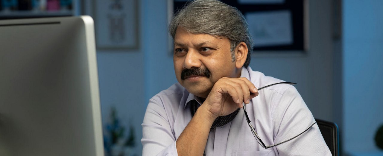 Un jeune professionnel pose avec assurance, téléphone en main, incarnant l'élégance et le dynamisme du monde des affaires.