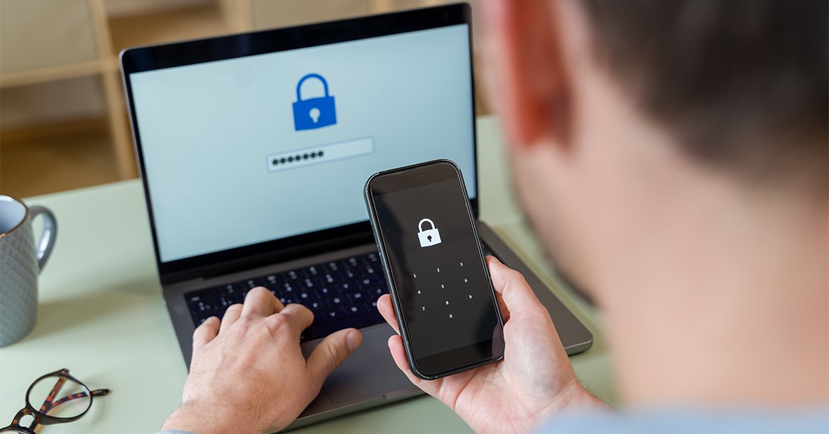 Personne utilisant l'authentification à deux facteurs sur un téléphone tout en tapant un mot de passe sur un ordinateur portable.
