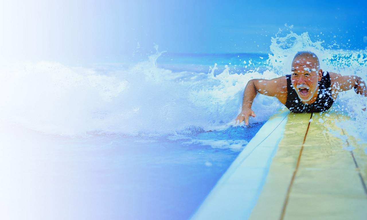 A woman stands by the beach, overlooking the blue ocean, with the summer sun reflecting on the calm sea water.