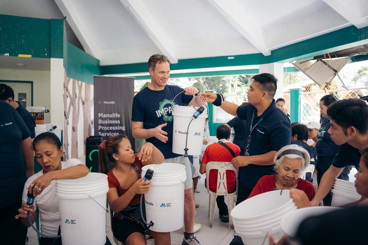 Volunteers distribute water filtration buckets