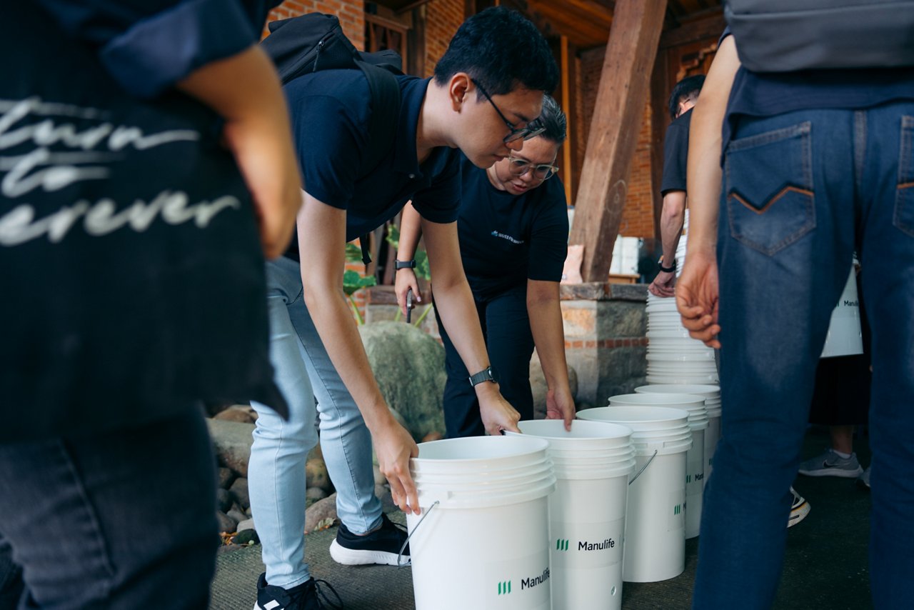 Volunteers arranging white Manulife buckets outdoors