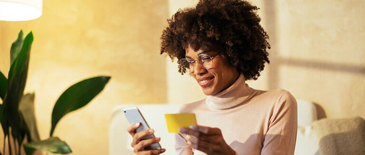 Woman copying something from a yellow piece of paper onto her phone