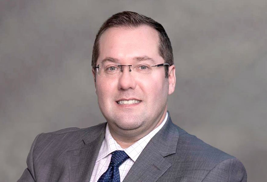 A professional portrait of a mature businessman, dressed in a suit, exemplifying the face of adult male leadership.