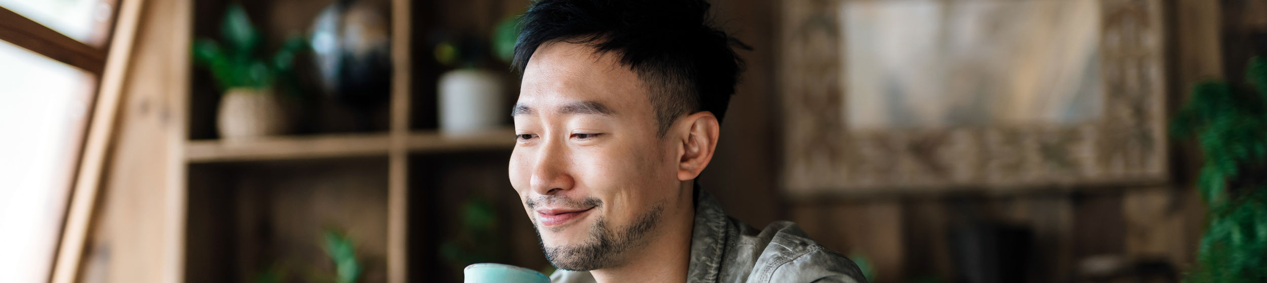 Young Asian man using laptop in the living room. Managing personal banking and investment via online banking. Making financial plan, planning savings and spending, managing online stock trades. E-banking with technology