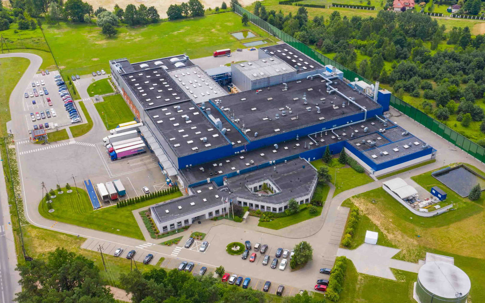Aerial view of goods warehouse. Logistics center in industrial city zone from above. Aerial view of trucks loading at logistic center