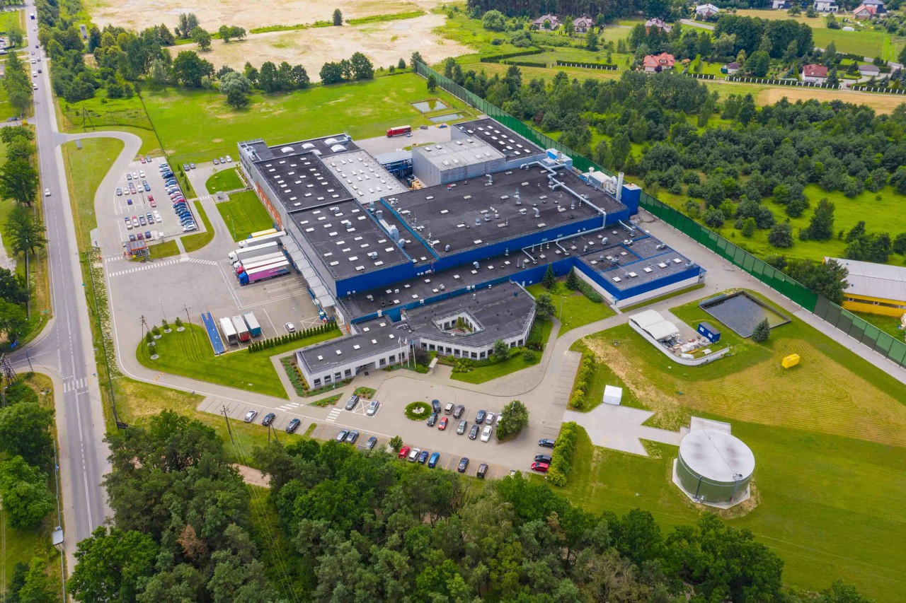 Aerial view of goods warehouse. Logistics center in industrial city zone from above. Aerial view of trucks loading at logistic center
