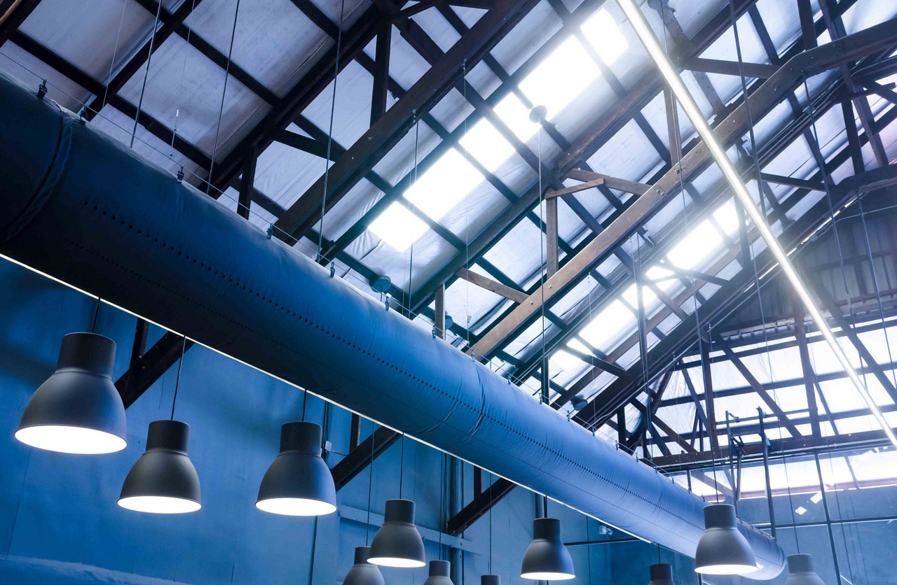 Industrial warehouse interior of roof ceiling structure skylights with ventilation air ducts and pendant lamps