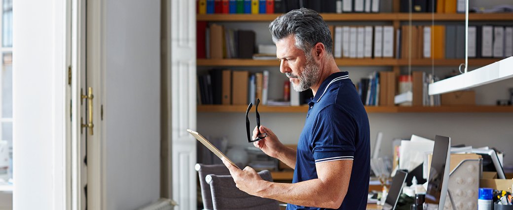 A diverse group of adult men and women engage in educational activities within an indoor library setting.