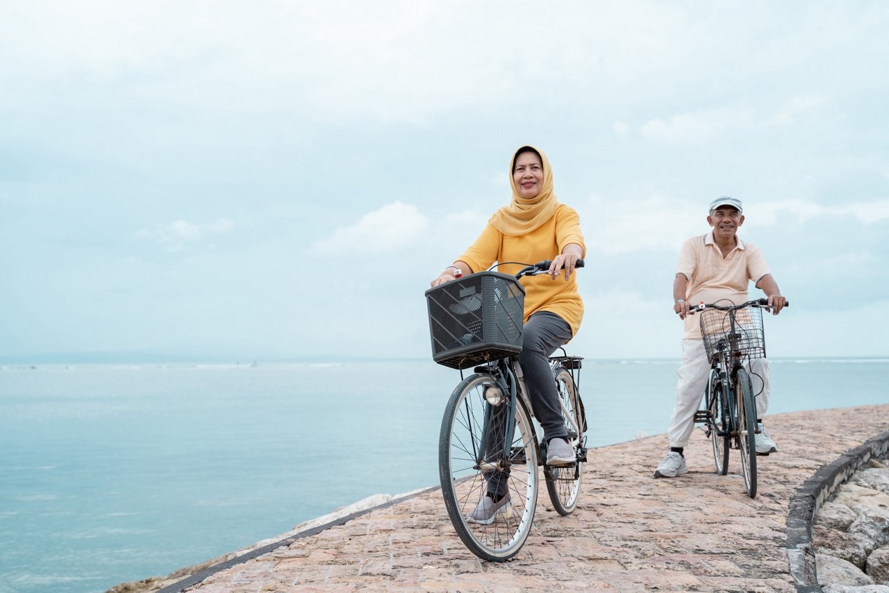 portrait of old couple ride bicycle and workout together outdoor