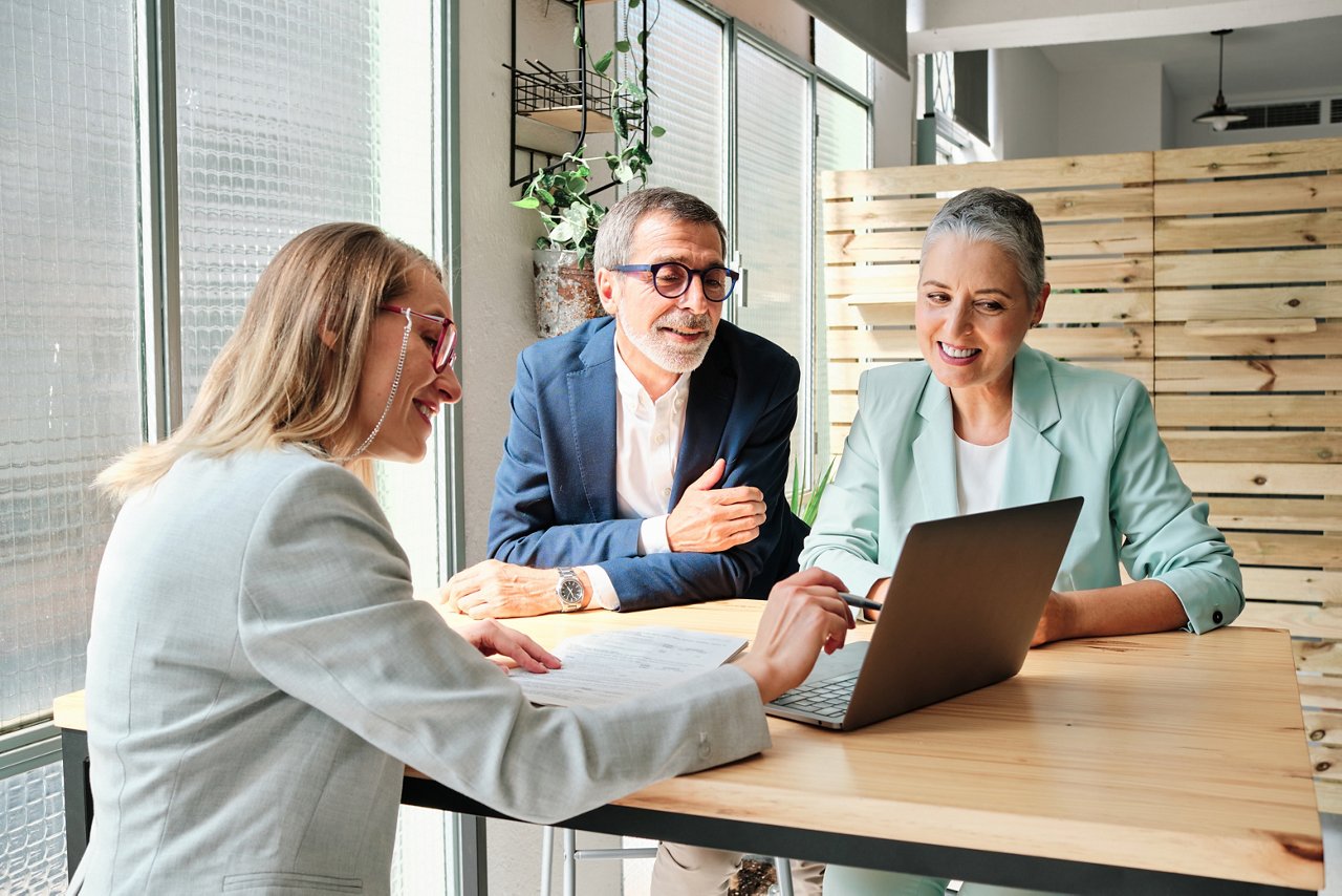 A financial advisor sitting at a desk with two clients